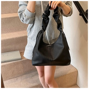 Detail of black pebbled leather texture and ruched cloud handle on the hobo shoulder bag