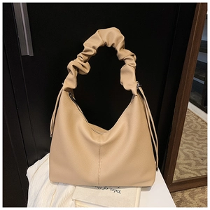 Detail of beige hobo bag with textured pebble leather and ruched cloud handle