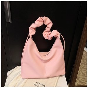 Detailed shot of pink hobo bag with litchi grain texture and ruched scrunchie handle