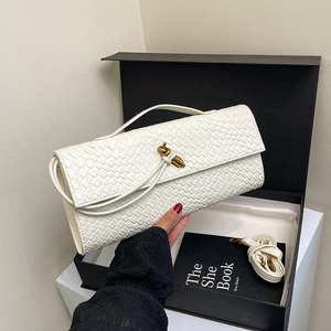 Off-white woven leather baguette bag with brass twist lock shown in premium gift box