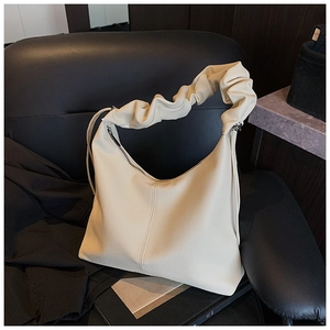 Detailed view of beige hobo bag featuring lychee grain texture and cloud pleated shoulder strap