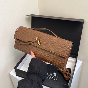 Brown woven envelope bag with gold twist lock and crossbody strap in a gift box