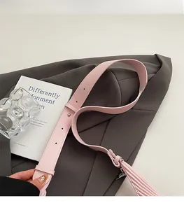 Detail of adjustable pale pink leather shoulder strap with silver buckle and fine stitching