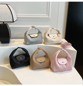 Detail view of colorful pleated handbags on display showcasing texture and leather finish