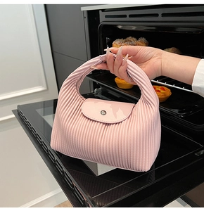 Detail of pink pleated hobo bag featuring leather flap and silver metal snap button closure