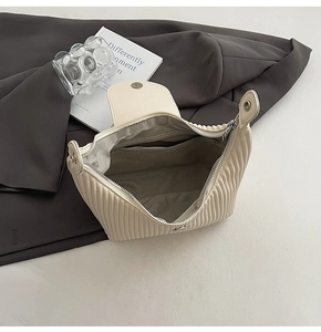 Detailed view of the pleated handbag interior with spacious main compartment and zip pocket