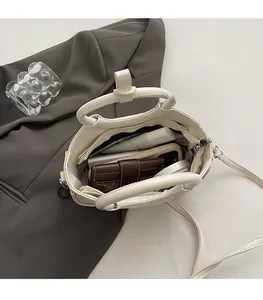 Spacious interior of beige saddle bag showing storage for phone and cosmetics