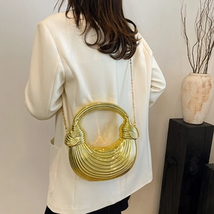Golden acrylic shell bag with striped texture and circular handle for evening wear