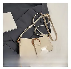 Détail du sac croissant crème avec boucle ronde en bronze vintage et bandoulière