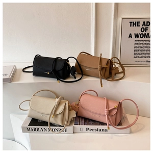 Detail of four colorful lychee grain leather crossbody bags with gold hardware accents