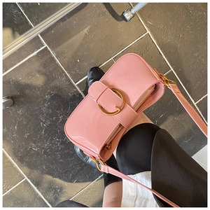 Vue détaillée du sac baguette en cuir verni rose avec boucle dorée et fermeture éclair