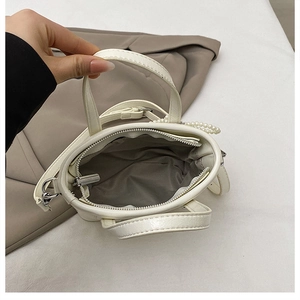 Détail intérieur du sac seau blanc avec fermeture éclair argentée et bandoulière en perles