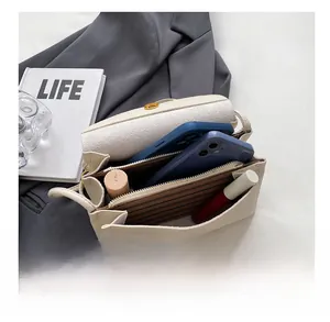 Interior view showing capacity of beige pebbled leather bag holding phones and cosmetics