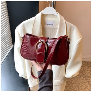 Détail du sac baguette en cuir verni bordeaux avec boucle en métal doré chic