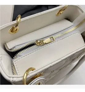 Détail d'un sac à main en cuir matelassé blanc avec fermeture éclair en métal doré lisse