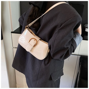 Détail du sac sous le bras en cuir verni blanc crème avec finition brillante et boucle