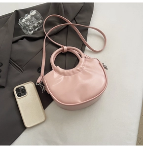 Detailed top view of a pink PU leather crescent saddle bag with round handle and strap