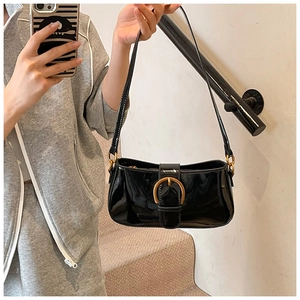 Détail d'un sac sous le bras en cuir verni noir brillant avec boucle en fer à cheval