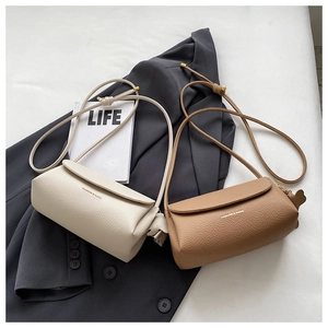 Detail of soft pebbled leather flap bag with fashion text and golden ball metal buckle