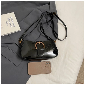 Détail du sac bandoulière en cuir verni noir avec finition brillante et boucle dorée