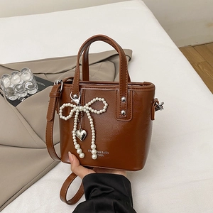 Sac seau marron en cuir avec nœud en perles et pendentif cœur pour porté épaule
