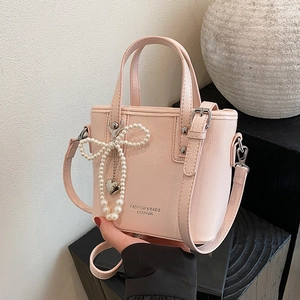 Sac seau rose à texture litchi avec nœud en perles et bandoulière réglable