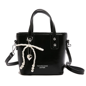 Sac seau en cuir verni noir avec breloque nœud en perles et bandoulière amovible