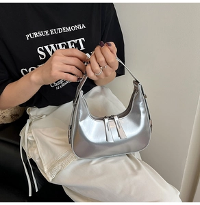 Close-up of silver moon bag with metallic PU leather and decorative long zipper pulls