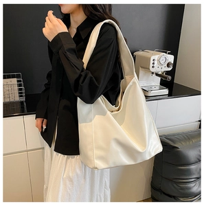 Minimalist beige hobo bag made of soft faux leather shown on a model for daily use