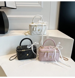 Detailed shot of quilted chain bags in white, black, and pink with lace bows