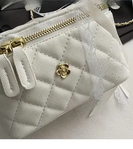 Detail of white quilted handbag featuring a golden camellia clasp and lace ribbon decor