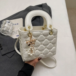 Sac à main blanc crème matelassé avec surpiqûres en cœur et pendentif perle nœud