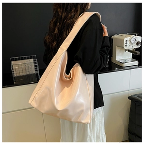 Detail of soft leather hobo bucket bag with glossy finish and wide shoulder strap