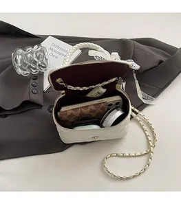 Detail of white quilted vanity case bag showing spacious interior with burgundy lining