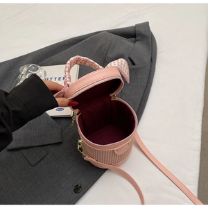Pink bucket bag showing dark red fabric lining and silk scarf wrapped handle detail