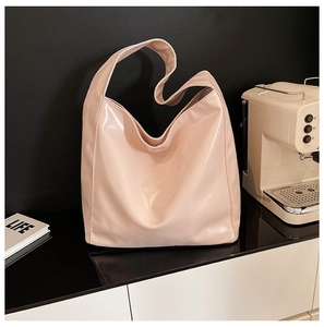 Modern pink patent leather hobo bag on a minimalist bar counter with decor