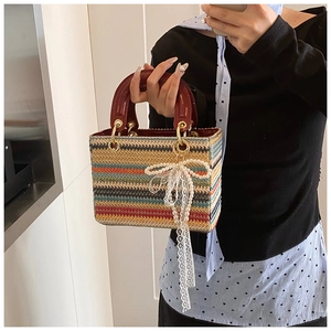Détail d'un mini sac tissé coloré avec poignées en cuir rouge et breloque en perles