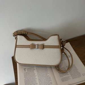 Chic white woven crossbody bag with brown leather trim and knotted strap detail