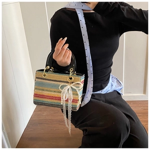 Gros plan du sac tissé avec rayures multicolores et nœud décoratif en perles