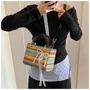 Détail d'un sac à main tissé coloré orné d'un nœud en perles et de rubans en dentelle