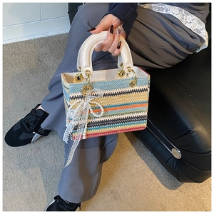 Détail du sac tissé à rayures arc-en-ciel avec nœud en dentelle perlée et poignée