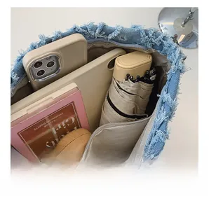 Interior view of denim underarm bag showing large capacity for essentials and zip pocket
