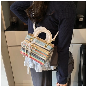 Détail du sac tissé avec rayures arc-en-ciel, nœud en perles et bandoulière en cuir