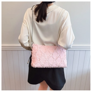 Detail of pink denim underarm bag featuring fringe quilting and a silver chain strap