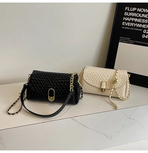 Detail of woven faux leather shoulder bags in black and beige with gold chain straps