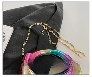 Detailed close-up of iridescent gradient surface and gold metal chain strap on circular bag