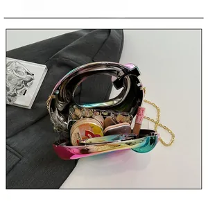 Internal view of iridescent G-shaped evening bag showing makeup and cardholder capacity