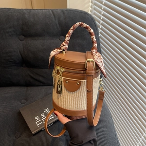 Chic brown leather and straw bucket bag with silk scarf handle and adjustable strap