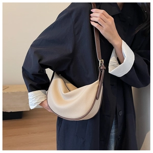 Dettaglio della borsa hobo in pelle crema con tracolla marrone e zip in metallo