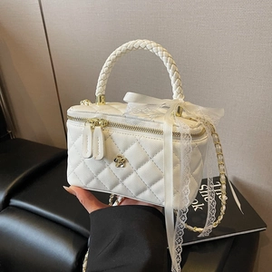 White quilted crossbody bag with woven handle and elegant lace ribbon detail